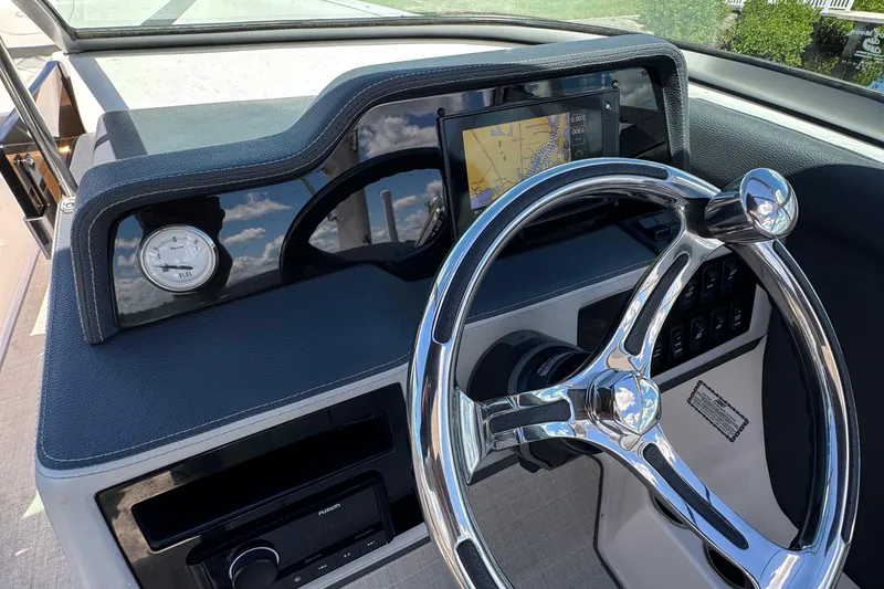 Slide: The Image of 2021 Regal 26 OBX boat dashboard with steering wheel and navigation display. - 14