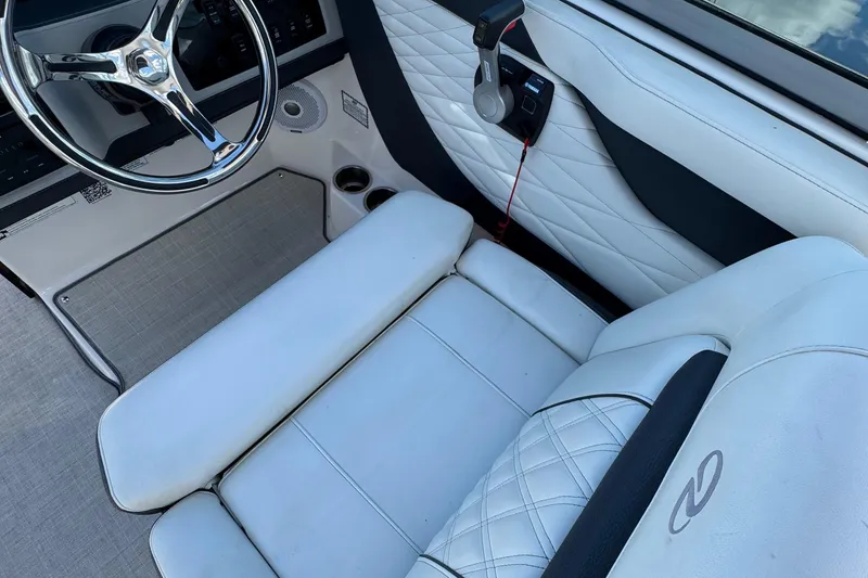Slide: The Image of 2021 Regal 26 OBX boat interior with white leather seating and steering wheel. - 15