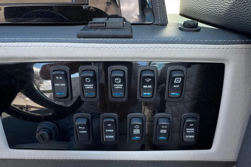 Slide: The Image of Control panel of a 2021 Regal 26 OBX boat with various switches. - 16