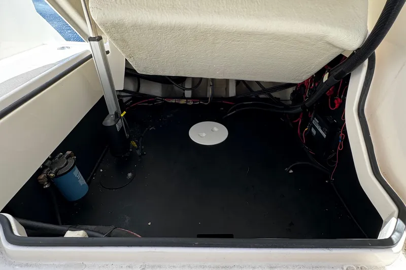 Slide: The Image of 2021 Regal 26 OBX boat storage compartment with visible wiring and components. - 24