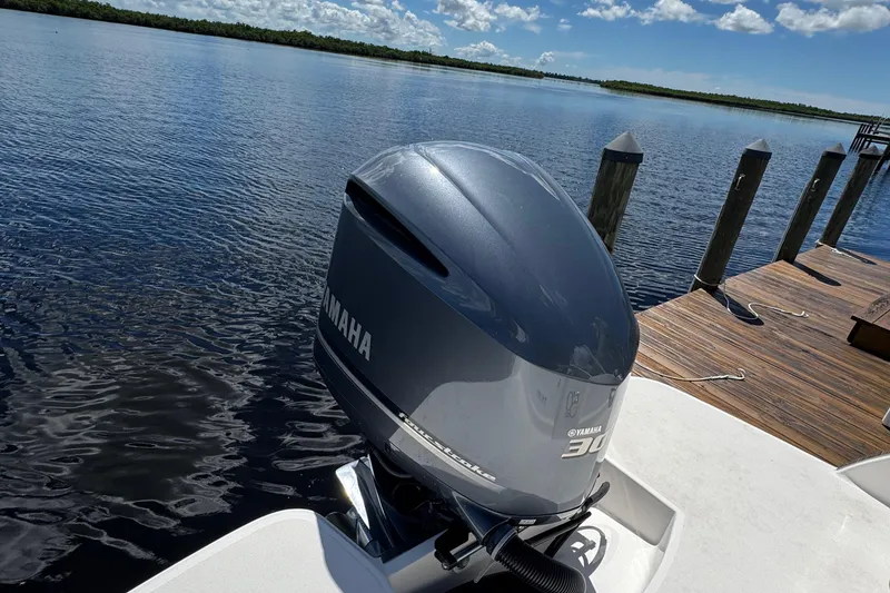 Slide: The Image of 2021 Regal 26 OBX with Yamaha outboard motor docked by a serene lake. - 27