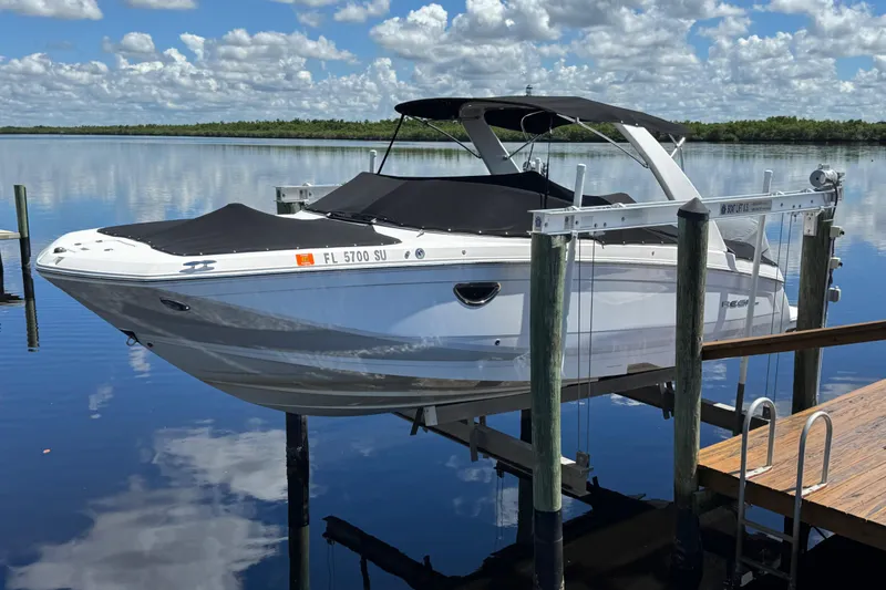 Slide: The Image of 2021 Regal 26 OBX boat docked on a lift over calm water. - 3
