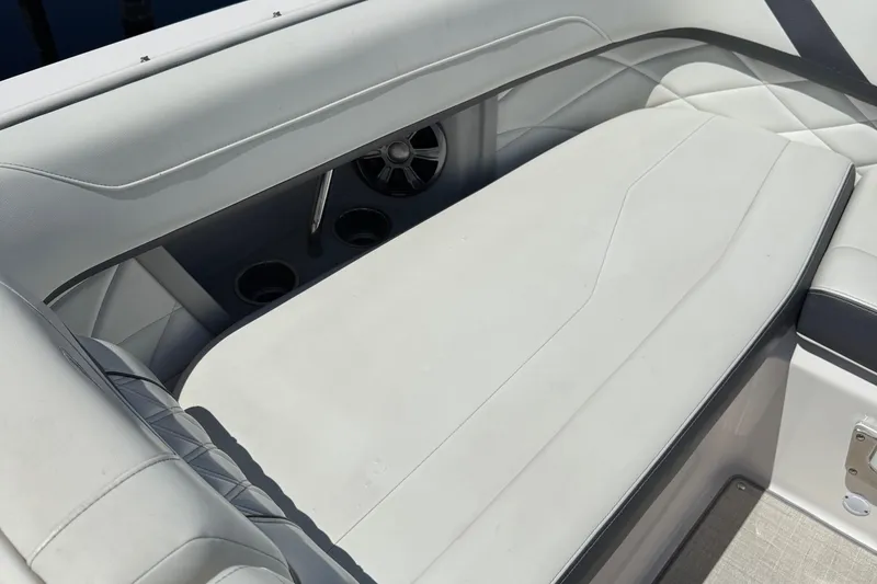 Slide: The Image of 2021 Regal 26 OBX boat interior with white cushioned seating and cup holders. - 7