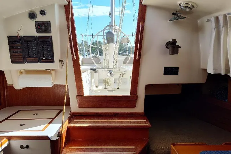 Slide: The Image of Interior view of a 1979 Bristol Yawl sailboat, showcasing wooden finishes and navigation equipment. - 14