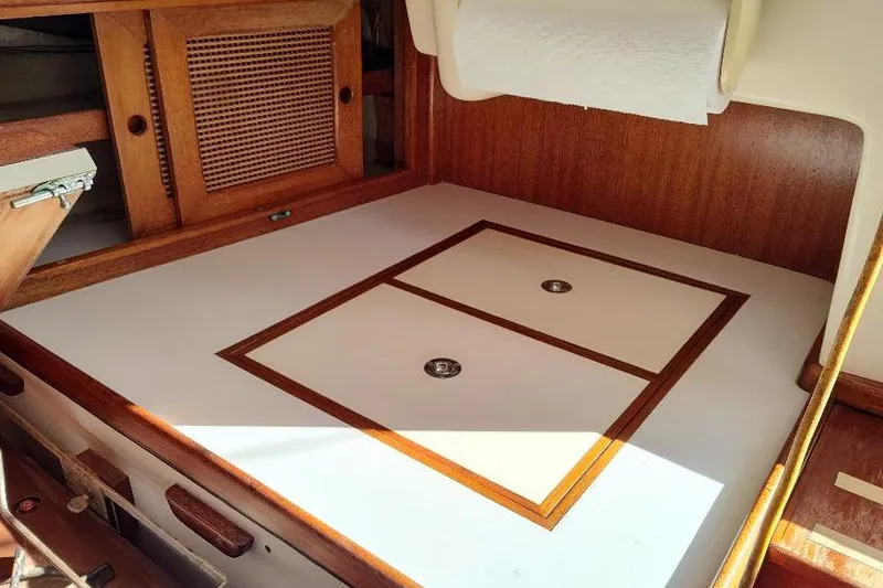 Slide: The Image of Interior of a 1979 Bristol Yawl sailboat, featuring wooden cabinetry and storage compartments. - 20
