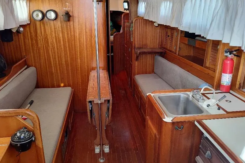 Slide: The Image of Interior of a 1979 Bristol Yawl sailboat with wooden furnishings and compact kitchen. - 23