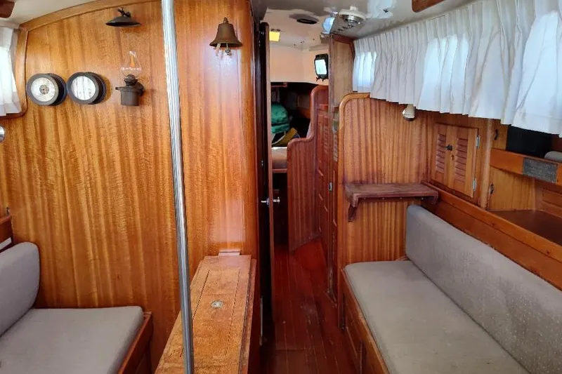 Slide: The Image of Interior of a 1979 Bristol Yawl sailboat with wooden paneling and seating. - 24