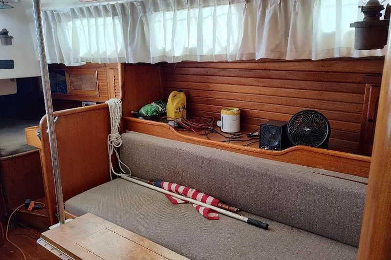 Slide: The Image of Interior of a 1979 Bristol Yawl sailboat with wooden paneling and seating area. - 29
