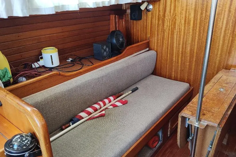 Slide: The Image of Interior of a 1979 Bristol Yawl sailboat with wooden paneling and seating area. - 31
