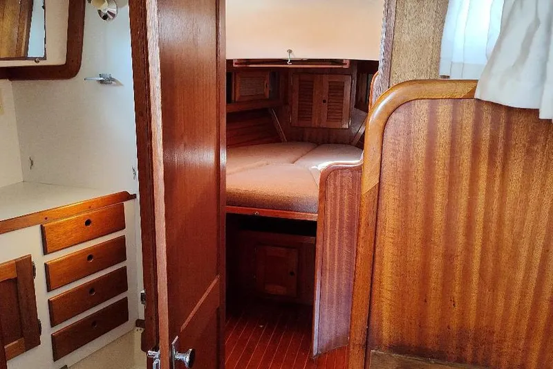 Slide: The Image of Interior of a 1979 Bristol Yawl sailboat with wooden cabinetry and cozy sleeping area. - 32