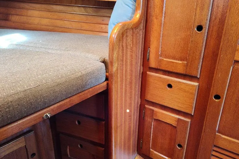 Slide: The Image of Interior of a 1979 Bristol Yawl, featuring wooden cabinetry and cushioned seating. - 36