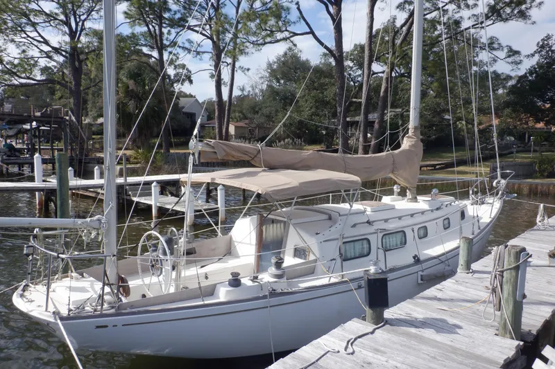 Slide: The Image of 1979 Bristol Yawl sailboat docked at a marina, surrounded by trees and calm water. - 4