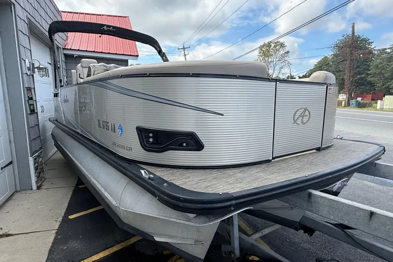 Slide: The Image of 2019 Avalon 2285 LSZ Cruise Tri-toon boat on trailer, parked beside a building. - 10
