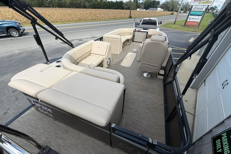 Slide: The Image of 2019 Avalon 2285 LSZ Cruise Tri-toon boat with beige seating, parked on roadside. - 11