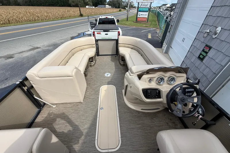 Slide: The Image of 2019 Avalon 2285 LSZ Cruise pontoon boat interior with beige seating and steering console. - 14