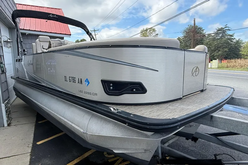 Slide: The Image of 2019 Avalon 2285 LSZ Cruise Tri-toon boat on trailer, parked near a building. - 8