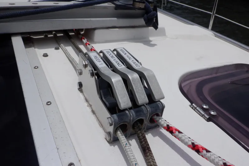 Slide: The Image of Close-up of sailboat rigging on a 1989 Hunter Vision 32, showing labeled rope clutches. - 12