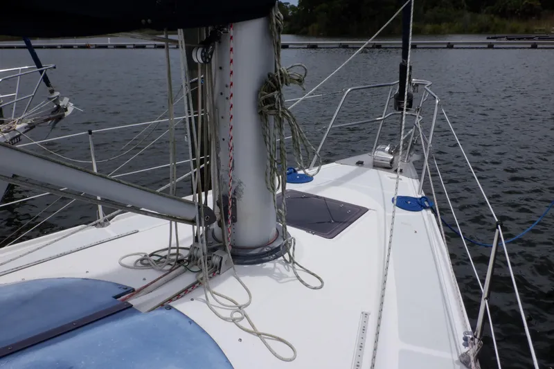 Slide: The Image of 1989 Hunter Vision 32 sailboat deck with mast and rigging on calm water. - 15
