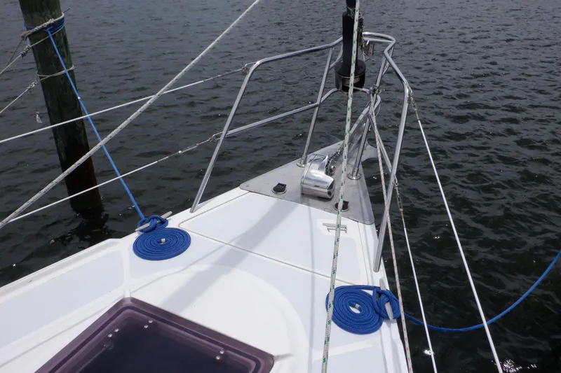 Slide: The Image of Bow of 1989 Hunter Vision 32 sailboat with blue ropes and water view. - 16