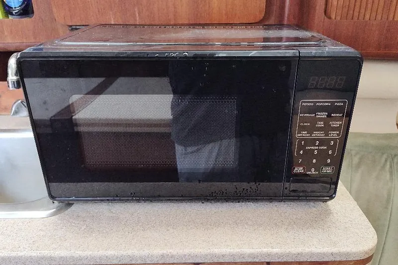 Slide: The Image of Black microwave on a kitchen counter inside a 1989 Hunter Vision 32 boat. - 28