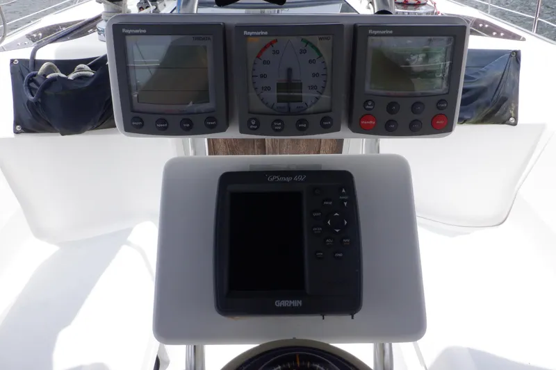 Slide: The Image of Cockpit instruments on a 1989 Hunter Vision 32 sailboat, featuring Raymarine and Garmin displays. - 5