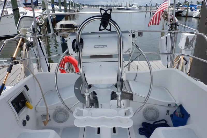 Slide: The Image of Cockpit of 1989 Hunter Vision 32 sailboat with steering wheel and marina view. - 8