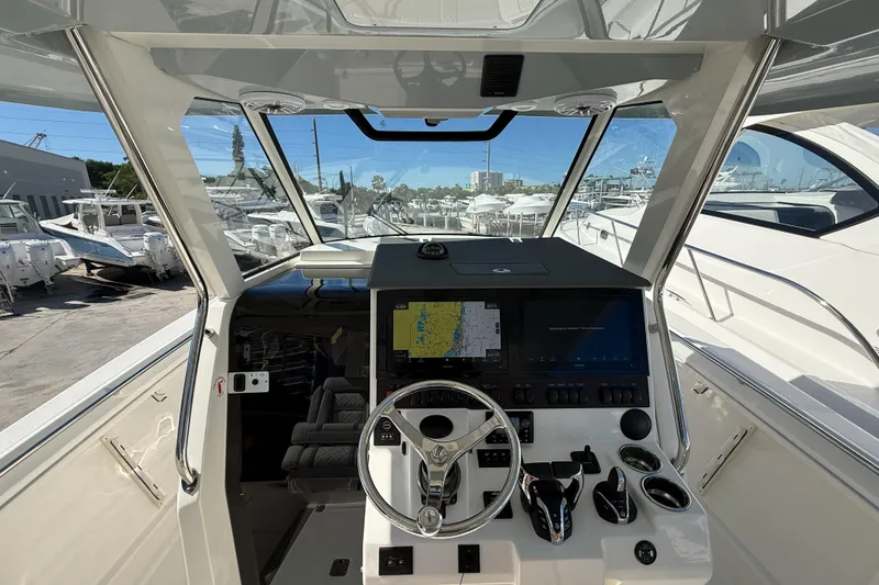 Slide: The Image of 2025 Pursuit S 358 Sport boat cockpit with advanced navigation system and steering wheel. - 2