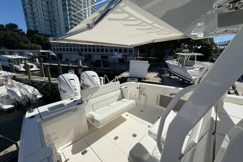 Slide: The Image of 2025 Pursuit S 358 Sport boat interior with seating, docked near other boats. - 4