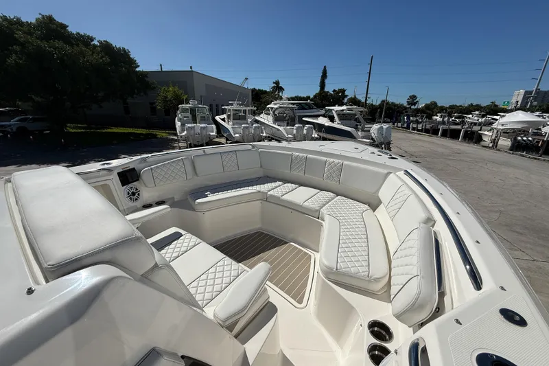 Slide: The Image of 2025 Pursuit S 358 Sport boat with luxurious seating and modern design in a marina setting. - 5
