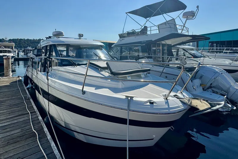 Slide: The Image of 2020 Jeanneau NC 895 boat docked at a marina under clear blue skies. - 11