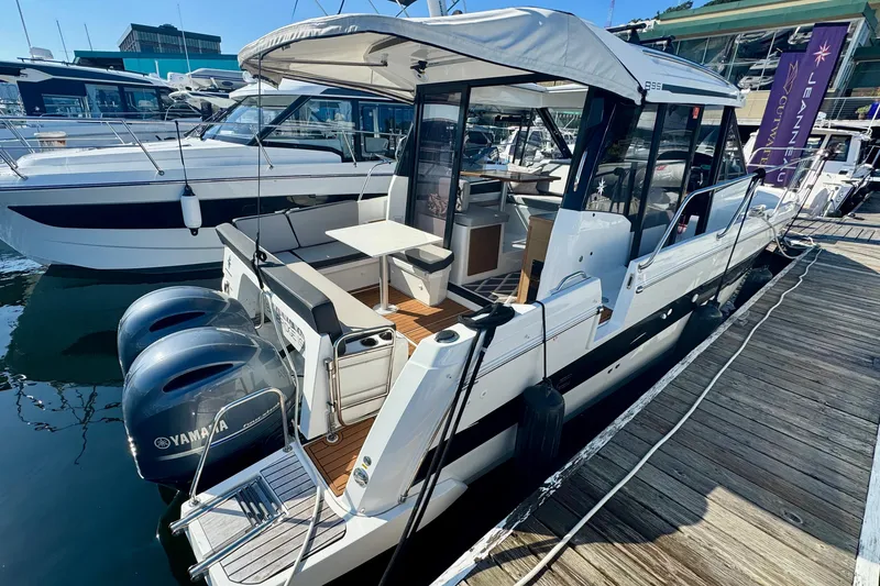 Slide: The Image of 2020 Jeanneau NC 895 boat docked, featuring twin Yamaha engines and spacious deck area. - 13