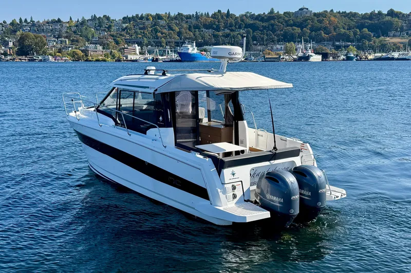 Slide: The Image of 2020 Jeanneau NC 895 boat on water with twin Yamaha engines, scenic background. - 4