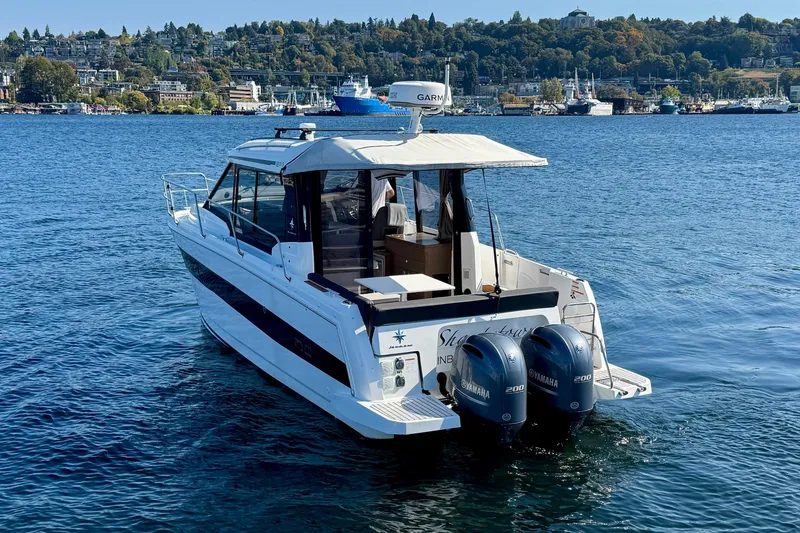 Slide: The Image of 2020 Jeanneau NC 895 boat with twin Yamaha engines on a scenic lake. - 5