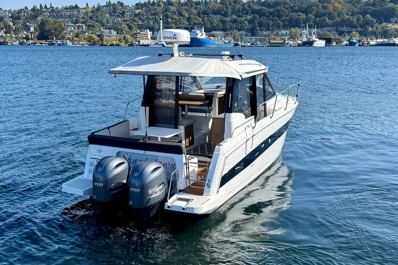 Slide: The Image of 2020 Jeanneau NC 895 boat with twin Yamaha engines on a scenic lake. - 7