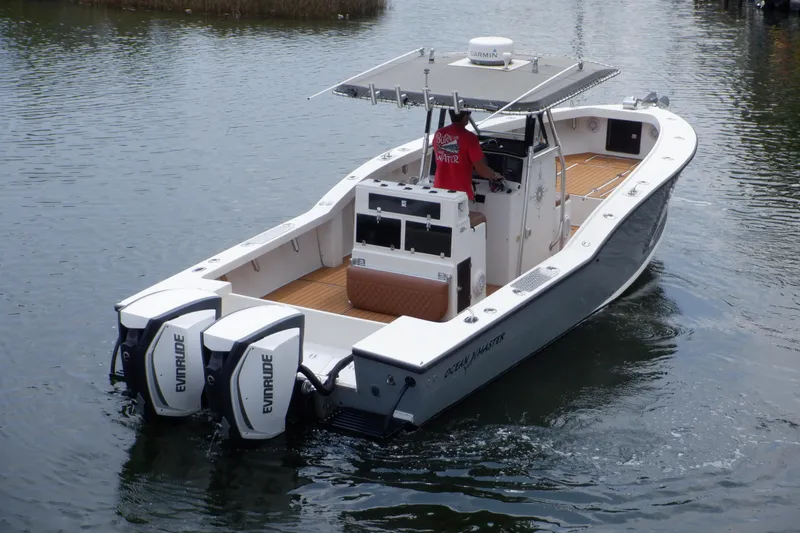 Slide: The Image of 1995 Ocean Master 31 Center Console boat with dual Evinrude engines on water. - 1