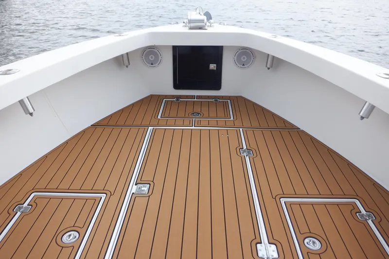 Slide: The Image of 1995 Ocean Master 31 Center Console boat deck with teak flooring, on calm water. - 23