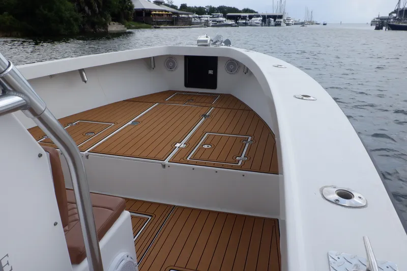 Slide: The Image of 1995 Ocean Master 31 Center Console boat with teak deck, docked by the marina. - 26