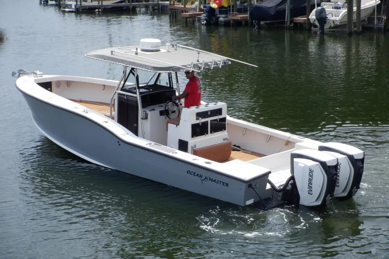 Slide: The Image of 1995 Ocean Master 31 Center Console boat with dual Evinrude engines on water. - 4