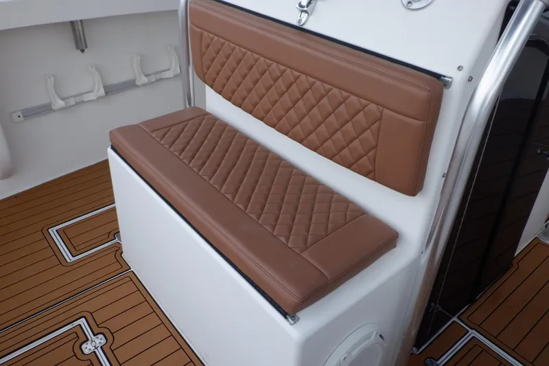 Slide: The Image of Brown cushioned seating on 1995 Ocean Master 31 Center Console boat, featuring teak-style flooring. - 42