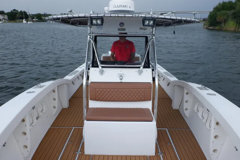 Slide: The Image of 1995 Ocean Master 31 Center Console boat on water, featuring teak deck and cushioned seating. - 44