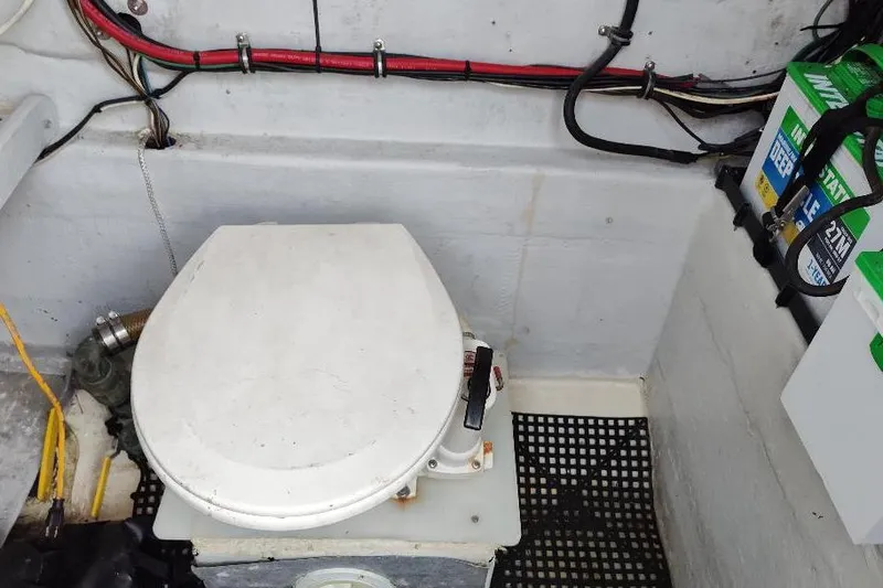 Slide: The Image of 1995 Ocean Master 31 Center Console boat interior with marine toilet and battery setup. - 48