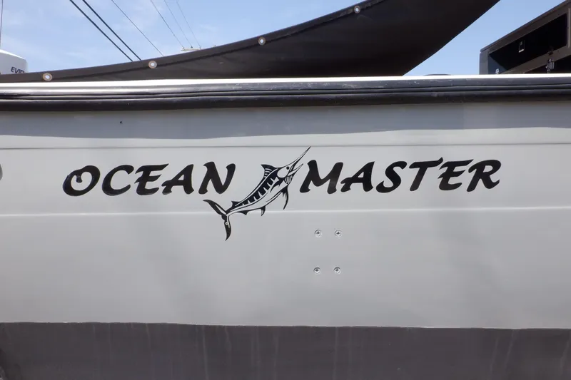 Slide: The Image of 1995 Ocean Master 31 Center Console boat with marlin logo on the side. - 49