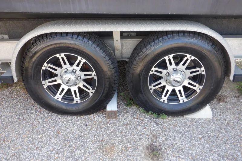 Slide: The Image of Trailer wheels of a 1995 Ocean Master 31 Center Console on gravel surface. - 57