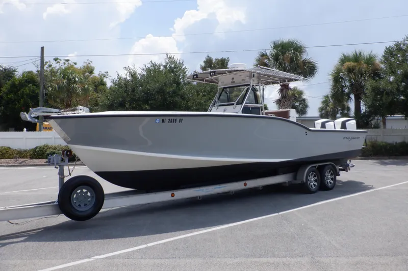 Slide: The Image of 1995 Ocean Master 31 Center Console boat on trailer, parked outdoors. - 9