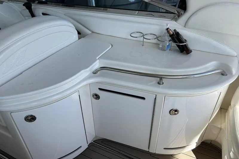 Slide: The Image of 2002 Sea Ray 290 Bowrider boat interior with white cabinetry and drink holders. - 10