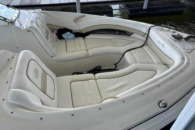 Slide: The Image of 2002 Sea Ray 290 Bowrider with spacious white leather seating in a docked position. - 8