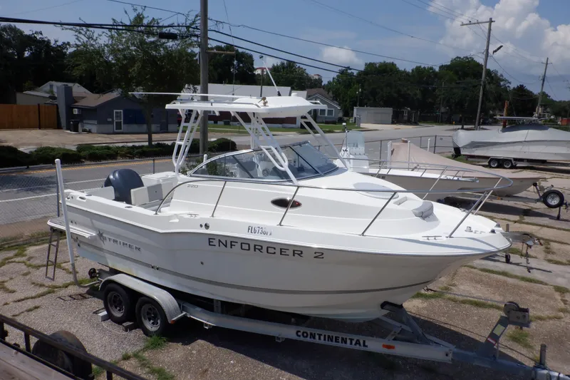 The Image of 2015 Seaswirl Striper 220 Walkaround boat on trailer, parked outdoors. - 0