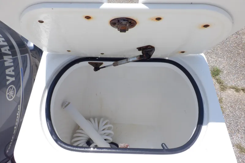Slide: The Image of Open storage compartment on 2015 Seaswirl Striper 220 Walkaround boat with Yamaha engine visible. - 19