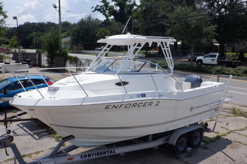 Slide: The Image of 2015 Seaswirl Striper 220 Walkaround boat on trailer, labeled "Enforcer 2." - 2