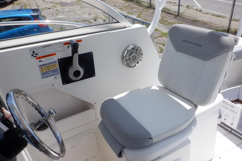 Slide: The Image of 2015 Seaswirl Striper 220 Walkaround boat interior with steering wheel and cushioned seat. - 21